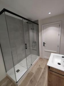łazienka z przeszkloną kabiną prysznicową i umywalką w obiekcie Céntrico apartamento inteligente w Grenadzie