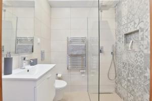 a white bathroom with a sink and a shower at Casa Rujo - Waterside Village House in Luz +10 photos