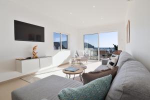 a living room with a couch and a tv at Casa Rujo - Waterside Village House in Luz