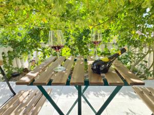 een houten tafel met twee glazen wijn erop bij Moutallos Rooms Inn Homes in Paphos City