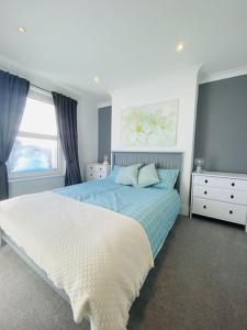 Habitación blanca con cama y ventana en Castle View 2 Bedroom Apartment in Town Centre, en Hastings