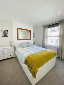a bedroom with a large bed with a yellow blanket at Castle View 2 Bedroom Apartment in Town Centre in Hastings