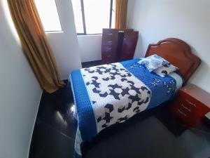 1 dormitorio con 1 cama con edredón de vaca en Apartamento muy amplio, Familiar cerca al Aeropuerto el Dorado, en Bogotá
