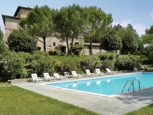 ein Swimmingpool mit Liegestühlen und ein Haus in der Unterkunft Apartment in Umbria near Lake Trasimeno in Mantignana