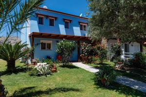 une maison avec un jardin en face dans l'établissement Posidonia Luxury Villas Kolympia, à Kolimbia
