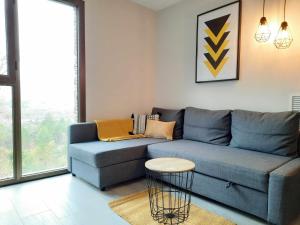 a living room with a blue couch and a table at Apartamentos Ordesa Ainsa in Aínsa