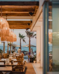 ヘルソニソスにあるGalazio Beach Resort by Estiaの海とヤシの木の景色を望むレストラン