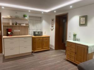 a kitchen with wooden cabinets and a counter top at Ferienwohnung Irene Dorn // Andechs in Andechs +19 photos