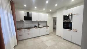 a white kitchen with white cabinets and appliances at Leben & Wohnen in einer historischen Villa in Bad Oeynhausen