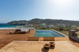 a backyard with a swimming pool and a wooden deck at Mileo in Kalo Livadi