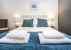 1 dormitorio con 1 cama grande con almohadas blancas en Seahaven, en North Berwick