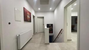 a hallway with white walls and a staircase with paintings at Leben & Wohnen in einer historischen Villa in Bad Oeynhausen