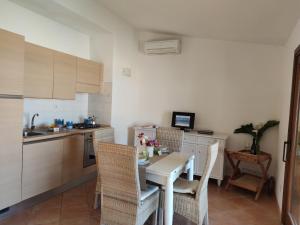 cocina con mesa y sillas en una habitación en Residence La Cala infinityholidays, en Costa Paradiso