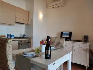 una cocina con una mesa con una botella de vino. en Residence La Cala infinityholidays, en Costa Paradiso
