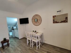 ein Esszimmer mit einem weißen Tisch und zwei Stühlen in der Unterkunft Da Dharma in Ventimiglia