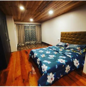 a bedroom with a bed with a blue comforter at Hello Home in Pelling