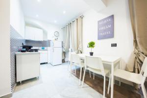 cocina y comedor con mesa blanca y sillas en Maccaja House by HolidayHome24, en Génova