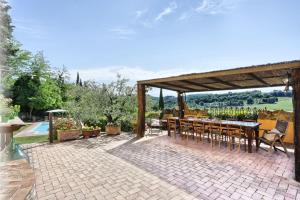 a patio with a table and chairs and a pavilion at Villa Sunshine in Gambassi Terme