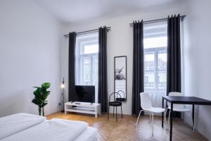um quarto com uma cama, uma secretária e uma mesa em Archibald Flats Prague em Praga