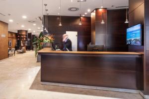 a man standing at a bar in a hotel lobby at Catalonia El Retiro in Madrid