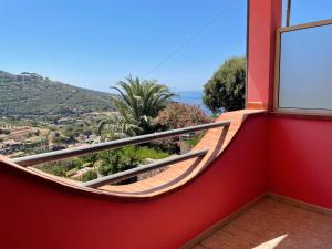 a red balcony with a view of the ocean at Villetta Grazia in Capoliveri
