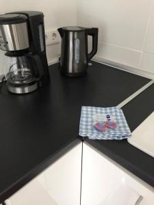 a black counter top with a coffee pot and a napkin at Insel Hus in Fehmarn