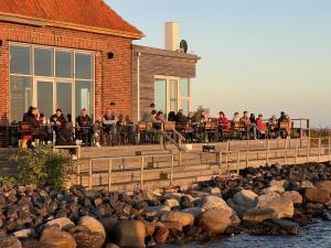 a group of people sitting at tables outside of a building at Insel Koje 1 in Fehmarn
