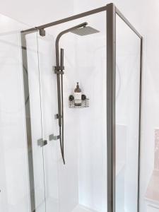 a shower with a glass door in a bathroom at The Hideaway - Guest House in Warrnambool