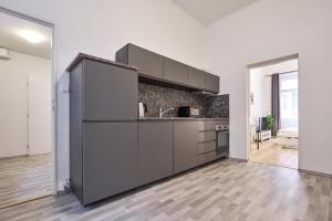 a kitchen with stainless steel appliances in a room at Archibald Flats Prague in Prague