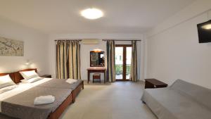 Cette chambre comprend deux lits et une télévision. dans l'établissement Villa Katerina Apartments, à Liapades