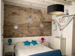 une chambre avec un lit et un mur de briques dans l'établissement La Herrería de Sagasta, à Cadix