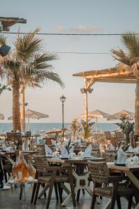 a restaurant with tables and chairs on the beach at Galazio Beach Resort by Estia in Hersonissos