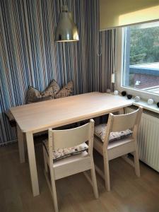 a dining room table with two chairs and a light fixture at Ferienwohnung Dein Lieblingsplatz 15201 in Leer +8 photos