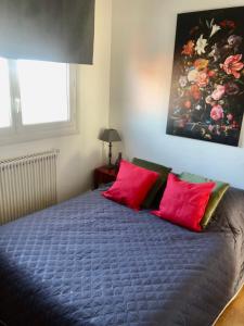 1 dormitorio con 1 cama con 2 almohadas rojas en Lapartchallandais, en Challans