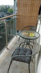 a table and chair sitting on a balcony at Shine24 - Spacious and bright apartment in Novi Sad