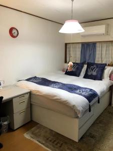 a bedroom with a large bed with blue pillows at kyoka house練馬 in Tokyo