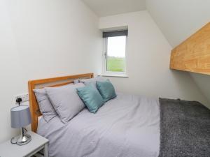 a bedroom with a bed with blue and white pillows at Elan Valley Welsh - The Sheepfold in Llandrindod Wells