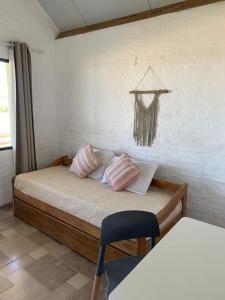 un dormitorio con una cama y una silla en Sabai Casas de Playa, en La Paloma