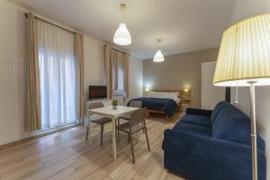 een woonkamer met een bank, een tafel en een bed bij Dalmati House San Lorenzo in Rome