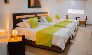 瓜亚基尔Hotel MC Suites - Confort cerca del Aeropuerto的酒店客房的三张床