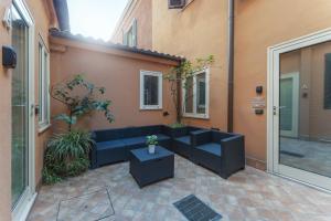 patio z niebieską kanapą i stołem w obiekcie Dalmati House San Lorenzo w Rzymie
