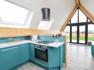 a kitchen with blue cabinets and a large window at Kerry Hill - The Sheepfold in Llandrindod Wells