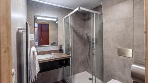 a bathroom with a shower and a sink at Madame Vacances Hotel Les Cimes in Vaujany