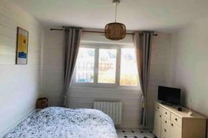 a bedroom with a bed and a window at Foch, proximité immédiate plage-port-commerces in Courseulles-sur-Mer