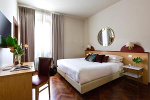a bedroom with a bed and a desk and a mirror at Aramis Rooms in Florence