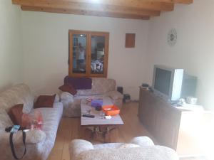 a living room with two couches and a tv at House with big garden next to the mountain river in Kruševo