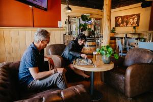 deux hommes assis à une table dans une pièce dans l'établissement Hotel de Zeeuwse Stromen - Duinpark, à Renesse