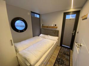 a small bed in a room with a window at Hausboot Fjord Luna mit Biosauna in Wendtorf in Wendtorf