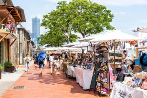 um mercado com pessoas andando por uma rua com mesas e guarda-chuvas em 闆娘公寓 em Kaohsiung