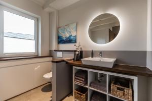 ein Bad mit einem Waschbecken und einem Spiegel in der Unterkunft Anne + Liese Haus in Lilienthal